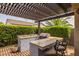 A fully equipped outdoor kitchen under a pergola, perfect for hosting summer barbecues and parties at 10154 E Bergeron Ave, Mesa, AZ 85212