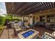 Expansive patio with a pergola, a full outdoor kitchen, and a cozy fire pit for entertaining guests at 10154 E Bergeron Ave, Mesa, AZ 85212