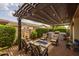 Inviting outdoor patio with a pergola, comfortable seating, brick pavers, and a fire pit for relaxing evenings at 10154 E Bergeron Ave, Mesa, AZ 85212