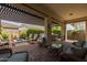 Spacious covered patio with a fire pit, comfortable seating, and outdoor bar at 10154 E Bergeron Ave, Mesa, AZ 85212