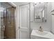 Bathroom featuring a sink, mirror, and a tiled walk-in shower at 1210 W Missouri Ave, Phoenix, AZ 85013