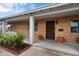 Inviting front porch with brick accents, a secure door, and a decorative rug, enhancing the home's curb appeal at 1210 W Missouri Ave, Phoenix, AZ 85013