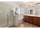 Bright bathroom with a glass-enclosed shower, a soaking tub, and double vanity sinks at 125 N 107Th Dr, Avondale, AZ 85323