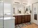 Well-lit bathroom with dual sinks, vanity, walk-in shower, and tile flooring at 125 N 107Th Dr, Avondale, AZ 85323