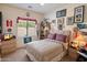 Cozy bedroom with a ceiling fan, window, carpet flooring, and plenty of wall decor at 125 N 107Th Dr, Avondale, AZ 85323