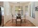 Bright breakfast nook features a glass-top table with seating for four and charming window views at 125 N 107Th Dr, Avondale, AZ 85323