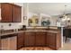 Functional kitchen featuring stainless steel appliances, rich wood cabinetry, and convenient access to the living areas at 125 N 107Th Dr, Avondale, AZ 85323