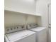 Clean and organized laundry room with a washing machine, dryer, and overhead shelving at 125 N 107Th Dr, Avondale, AZ 85323