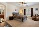 Spacious main bedroom with a ceiling fan, a large bed, a recliner, and neutral tones at 125 N 107Th Dr, Avondale, AZ 85323