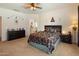 Open main bedroom with ensuite bathroom access, a ceiling fan, and carpeted flooring at 125 N 107Th Dr, Avondale, AZ 85323