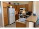 Cozy kitchen with light wood cabinets, white appliances, and a breakfast bar at 1406 W Emerald Ave # 124, Mesa, AZ 85202
