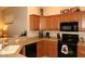 Kitchen featuring granite countertops, wooden cabinets, black appliances, and a stainless steel toaster at 14000 N 94Th St # 1031, Scottsdale, AZ 85260