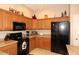Well-lit kitchen featuring granite countertops, wooden cabinetry, and modern black appliances at 14000 N 94Th St # 1031, Scottsdale, AZ 85260