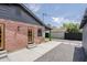 Exterior view of a brick home featuring a backyard with gravel, concrete, and a black privacy fence at 1551 W Vernon Ave, Phoenix, AZ 85007