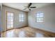 Light-filled bedroom with hardwood floors, ceiling fan, and direct access to the outdoors at 1551 W Vernon Ave, Phoenix, AZ 85007