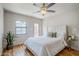 Cozy bedroom features a ceiling fan, wood floors, and large window with natural light at 1551 W Vernon Ave, Phoenix, AZ 85007