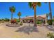 Beautiful backyard with covered patio, desert landscaping, and mature trees at 16280 W Desert Winds Dr, Surprise, AZ 85374