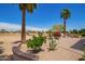 Beautiful backyard with desert landscaping, mature palm trees, and golf course views at 16280 W Desert Winds Dr, Surprise, AZ 85374