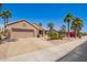 Charming single story home with desert landscaping, lush palms, and a two-car garage at 16280 W Desert Winds Dr, Surprise, AZ 85374