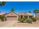 Charming single story home with desert landscaping, lush palms, and a two-car garage at 16280 W Desert Winds Dr, Surprise, AZ 85374