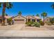 Charming single story home with desert landscaping, lush palms, and a two-car garage at 16280 W Desert Winds Dr, Surprise, AZ 85374