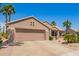 Charming single story home with desert landscaping, lush palms, and a two-car garage at 16280 W Desert Winds Dr, Surprise, AZ 85374