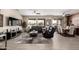 Spacious living room with stylish tile flooring, ceiling fans, and expansive windows with backyard views at 16280 W Desert Winds Dr, Surprise, AZ 85374