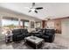 Spacious living room with stylish tile flooring, ceiling fans, and expansive windows with backyard views at 16280 W Desert Winds Dr, Surprise, AZ 85374
