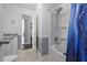 Bright bathroom featuring a shower/tub combo with a blue curtain, white cabinetry and neutral wall paint at 1654 S 77Th St, Mesa, AZ 85209