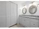 Clean bathroom featuring double vanity with granite counters and a linen closet at 1654 S 77Th St, Mesa, AZ 85209