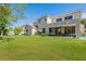 Large backyard with green grass, a covered patio, outdoor furniture, and the home's exterior at 18868 E Mockingbird Dr, Queen Creek, AZ 85142
