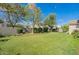 Sprawling backyard lawn surrounded by mature trees and shrubbery, perfect for outdoor activities at 18868 E Mockingbird Dr, Queen Creek, AZ 85142