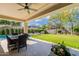 Inviting backyard with covered patio, outdoor dining, and beautiful lawn at 18868 E Mockingbird Dr, Queen Creek, AZ 85142