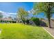 Large green backyard, bordered by a block fence, trees and manicured bushes, offering ample space at 18868 E Mockingbird Dr, Queen Creek, AZ 85142