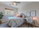 Bright bedroom featuring a charming bed frame, a cozy workspace, and a large window at 18868 E Mockingbird Dr, Queen Creek, AZ 85142