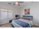 Cozy bedroom is illuminated by natural light, complemented by a modern desk and a ceiling fan at 18868 E Mockingbird Dr, Queen Creek, AZ 85142