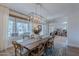 Bright dining room with wood table, stylish chairs and modern chandelier lighting fixture at 18868 E Mockingbird Dr, Queen Creek, AZ 85142
