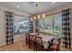 Bright dining room showcasing natural light with a backyard view, wood chairs and a modern chandelier at 18868 E Mockingbird Dr, Queen Creek, AZ 85142