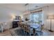 Dining room with modern lighting, wood table, and large window providing natural light, adjacent to a sideboard at 18868 E Mockingbird Dr, Queen Creek, AZ 85142