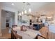 Open-concept dining room flowing into a modern kitchen with a large island and stainless steel appliances at 18868 E Mockingbird Dr, Queen Creek, AZ 85142