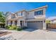 Attractive two-story home with a neutral color palette, a two-car garage, and manicured landscaping at 18868 E Mockingbird Dr, Queen Creek, AZ 85142
