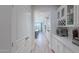 Hallway leading to a kitchen that includes modern appliances, white cabinets and long countertops at 18868 E Mockingbird Dr, Queen Creek, AZ 85142