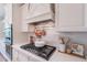Well-equipped kitchen featuring custom cabinetry, white countertops, tiled backsplash, and a stainless steel range hood at 18868 E Mockingbird Dr, Queen Creek, AZ 85142