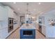 Bright kitchen with an island, stainless steel appliances, white cabinetry, and wood-look floors at 18868 E Mockingbird Dr, Queen Creek, AZ 85142