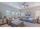 Inviting living room featuring a large sectional sofa, natural light, and a ceiling fan at 18868 E Mockingbird Dr, Queen Creek, AZ 85142