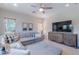 Bright living room featuring a large sectional sofa, modern TV and built-in cabinet at 18868 E Mockingbird Dr, Queen Creek, AZ 85142