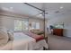Bright main bedroom with a four-poster bed, sitting area, and large windows at 18868 E Mockingbird Dr, Queen Creek, AZ 85142