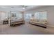 Bright main bedroom showcasing a canopy bed, large windows with blinds, and a comfortable sitting area at 18868 E Mockingbird Dr, Queen Creek, AZ 85142