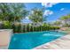 Refreshing pool with waterfall feature surrounded by lush greenery at 18868 E Mockingbird Dr, Queen Creek, AZ 85142