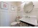 Charming powder room featuring classic fixtures, decorative wall paneling, and stylish framed artwork at 18868 E Mockingbird Dr, Queen Creek, AZ 85142